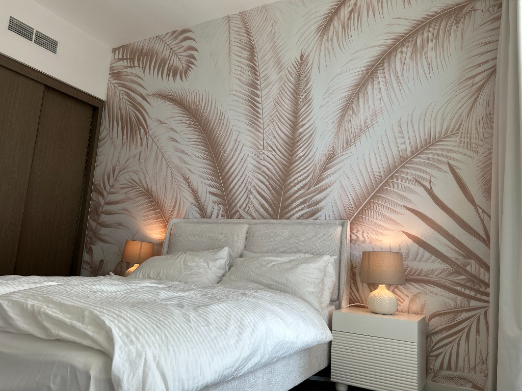 Bedroom with palm mural and hotel-quality bedding