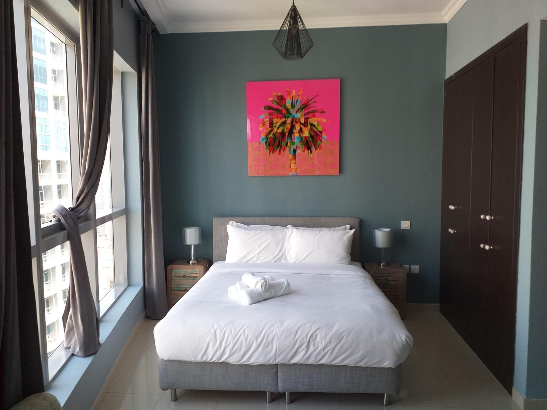 After — bedroom with teal wall and pop-art