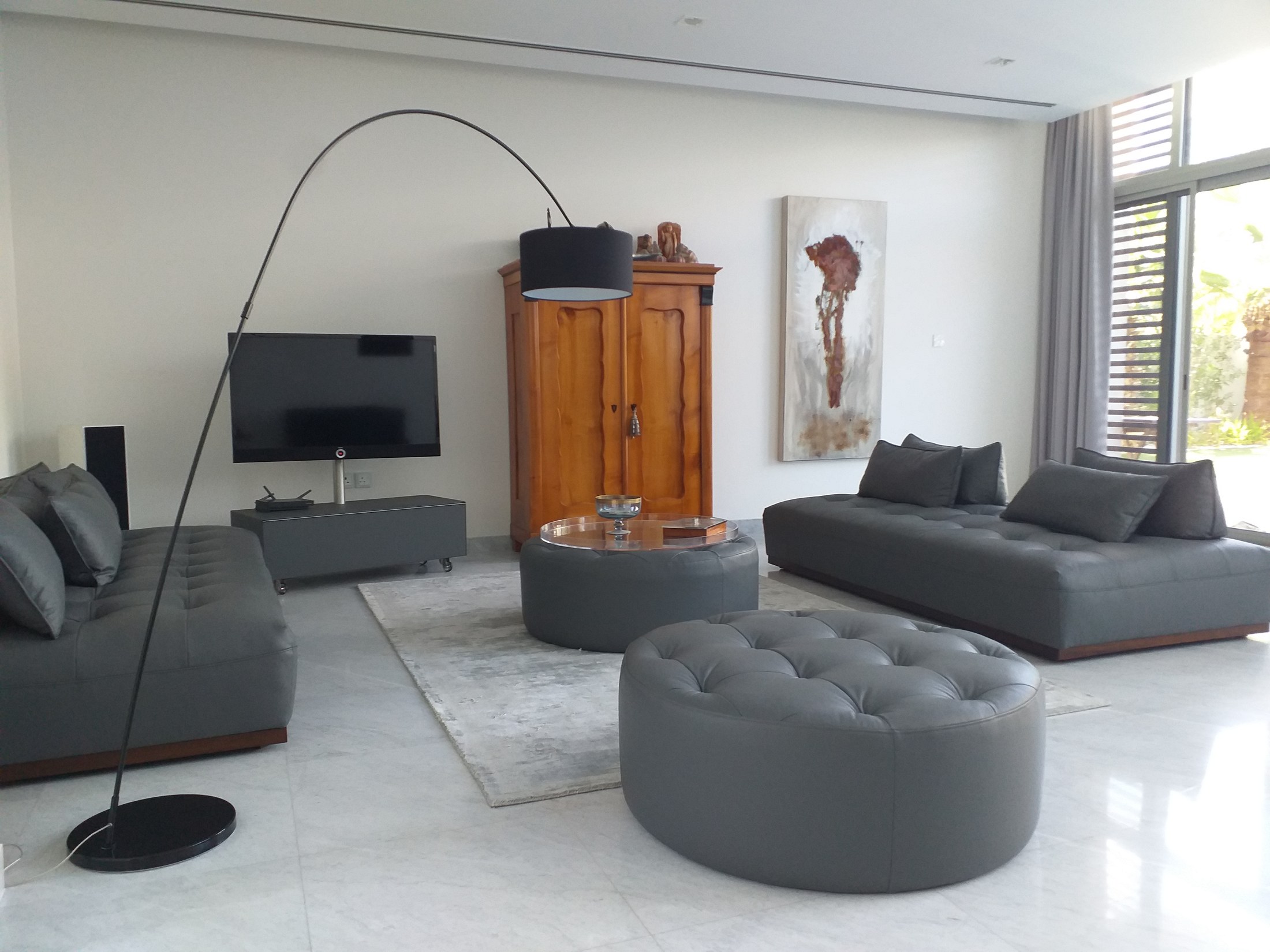 After — living room with grey sofas and arched lamp