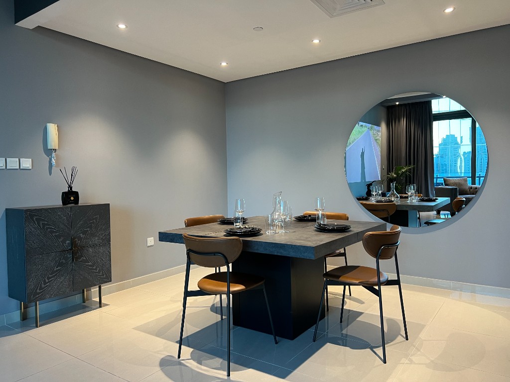 After — styled dining with leather chairs and round mirror