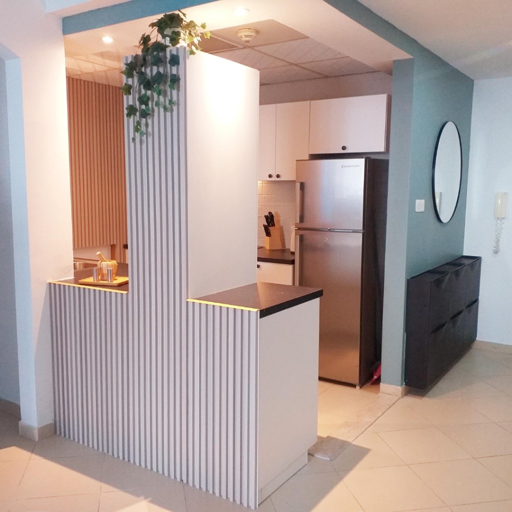 After — kitchen with slat island, white cabinets and round mirror