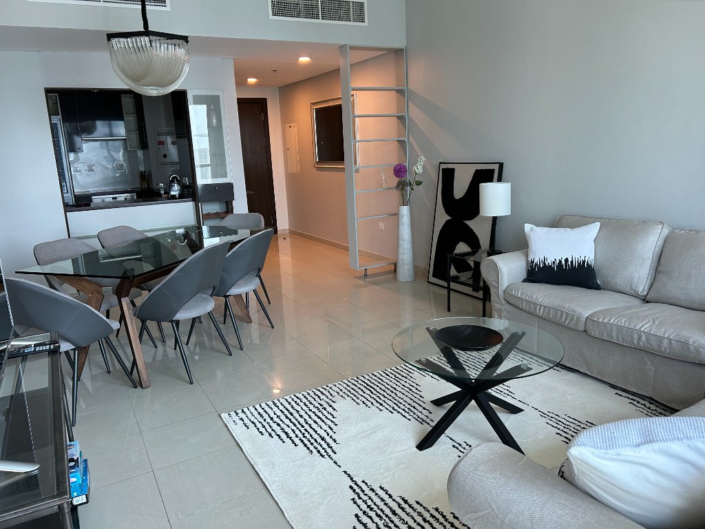 After — styled living and dining lounge with sofa, rug and pendant light